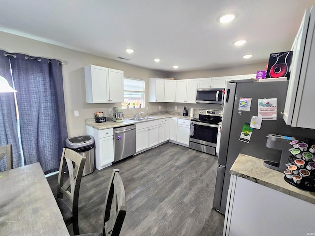 405 Ariel Dr, Kokomo, IN 46901 - kitchen featuring appliances with stainless steel finishes, a sink, white cabinets, dark wood-style floors, and light countertops