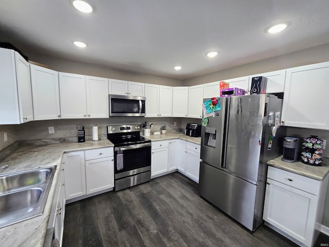405 Ariel Dr, Kokomo, IN 46901 - kitchen featuring stainless steel appliances, a sink, white cabinets, dark wood-type flooring, and light countertops