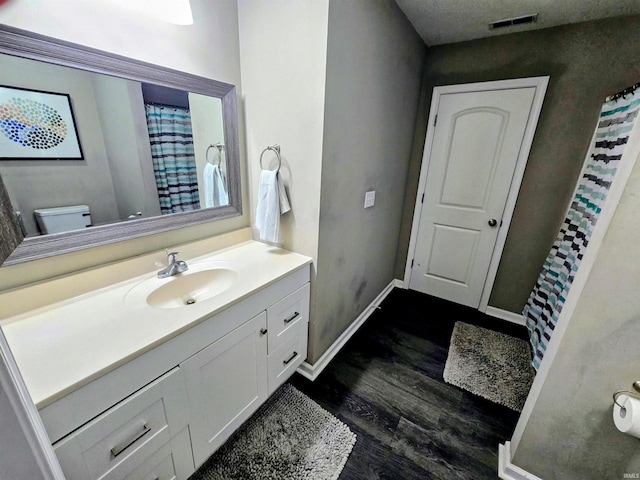 405 Ariel Dr, Kokomo, IN 46901 - bathroom with vanity, wood finished floors, toilet, baseboards, and a shower with shower curtain
