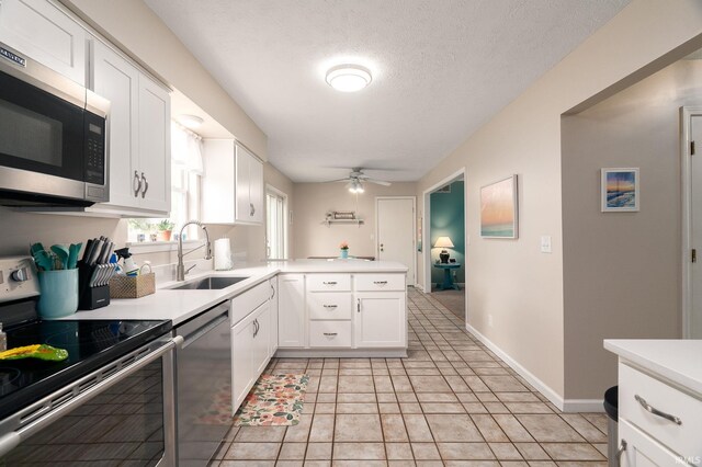 5203 Goldersgreen Dr, Lafayette, IN 47905 - kitchen with appliances with stainless steel finishes, a sink, ceiling fan, light countertops, and white cabinets