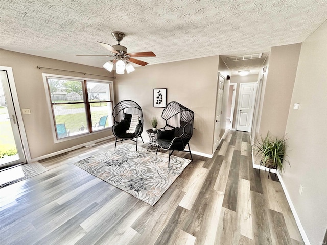 305 N Maude Dr, Rossville, IN 46065 - living area featuring wood finished floors, baseboards, attic access, ceiling fan, and a textured ceiling
