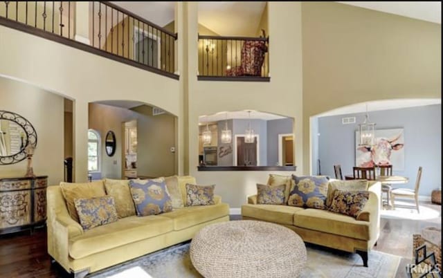 21562 Golden Maple Dr, South Bend, IN 46628 - living room featuring a high ceiling, wood finished floors, arched walkways, and baseboards