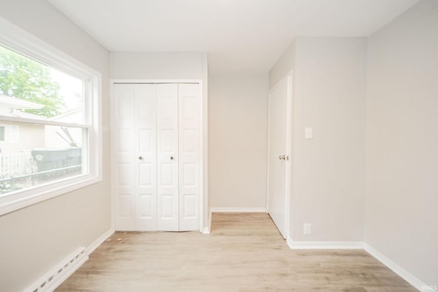2726 Apache Dr, Anderson, IN 46012 - unfurnished bedroom with a baseboard heating unit, light wood-style flooring, and baseboards