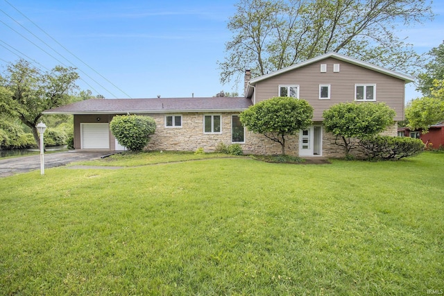 17330 Mcerlain St, South Bend, IN 46635 - view of front facade featuring stone siding, an attached garage, driveway, a chimney, and a front lawn