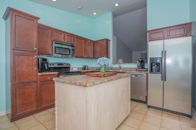 12908 Mattison Ct, Evansville, IN 47725 - kitchen with appliances with stainless steel finishes, a kitchen island, light tile patterned floors, a sink, and recessed lighting