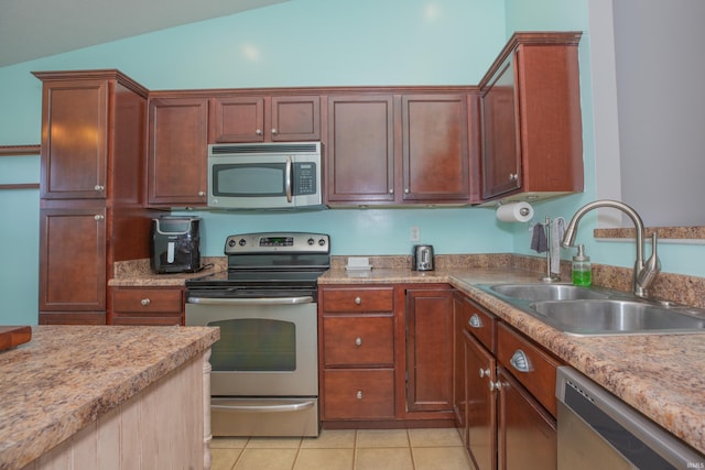 12908 Mattison Ct, Evansville, IN 47725 - kitchen with stainless steel appliances, a sink, vaulted ceiling, light countertops, and light tile patterned flooring