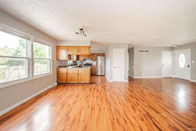 6863 W Jennifer Ct, Greenfield, IN 46140 - kitchen with appliances with stainless steel finishes, a textured ceiling, open floor plan, baseboards, and a sink