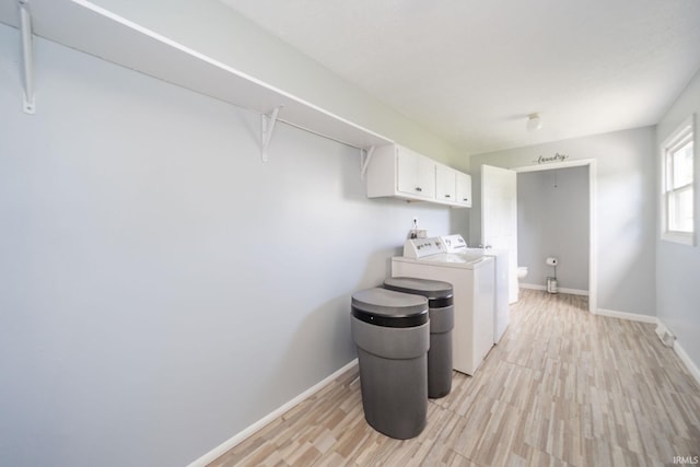 6863 W Jennifer Ct, Greenfield, IN 46140 - laundry area featuring cabinet space, washing machine and clothes dryer, light wood-style floors, and baseboards