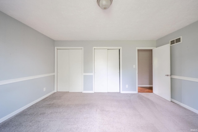 6863 W Jennifer Ct, Greenfield, IN 46140 - unfurnished bedroom featuring two closets, carpet flooring, and baseboards
