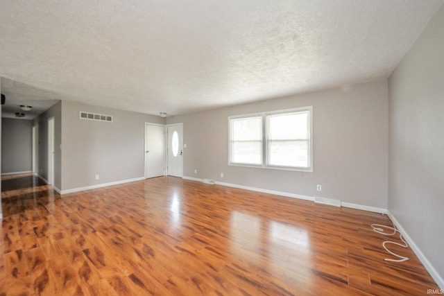 6863 W Jennifer Ct, Greenfield, IN 46140 - spare room with wood finished floors, a textured ceiling, and baseboards