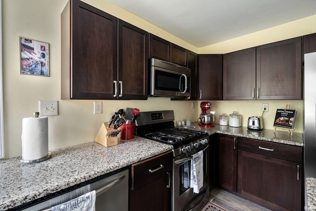 1905 Inglewood Pl, South Bend, IN 46616 - kitchen featuring stainless steel appliances, light stone countertops, dark brown cabinets, and wood finished floors