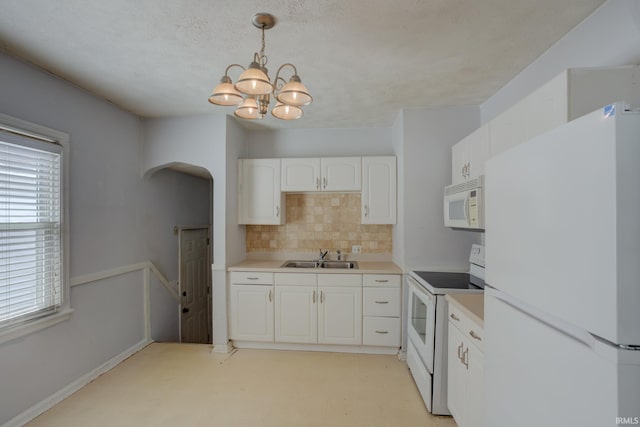 1521 Monroe Ave, Evansville, IN 47714 - kitchen with white appliances, arched walkways, tasteful backsplash, white cabinets, and a chandelier