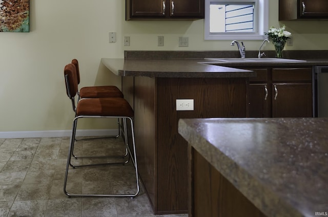 229 Ironwood Ln, Ossian, IN 46777 - kitchen with a sink, dark countertops, dark brown cabinets, baseboards, and dishwashing machine