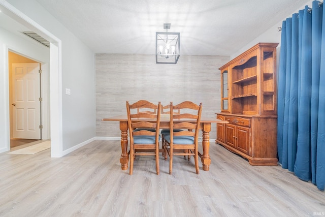 902 Hawthorne Ln, Logansport, IN 46947 - dining room with a chandelier, light wood-type flooring, baseboards, and an accent wall