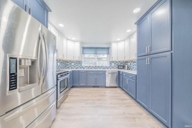 902 Hawthorne Ln, Logansport, IN 46947 - kitchen with stainless steel appliances, a sink, light countertops, light wood-type flooring, and tasteful backsplash