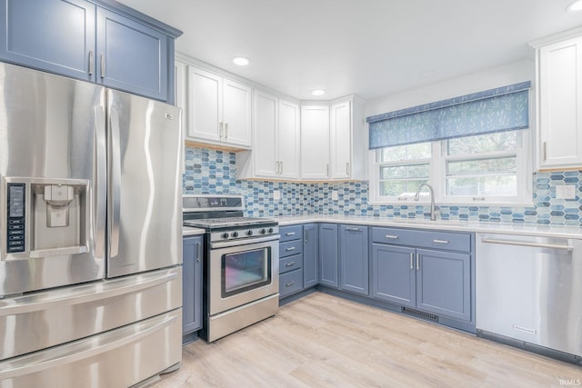 902 Hawthorne Ln, Logansport, IN 46947 - kitchen featuring stainless steel appliances, light countertops, white cabinetry, light wood finished floors, and tasteful backsplash