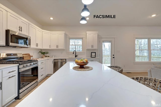 910 S Lantern Ln, Ellettsville, IN 47429 - kitchen featuring stainless steel appliances, a sink, white cabinetry, recessed lighting, and light wood-style floors