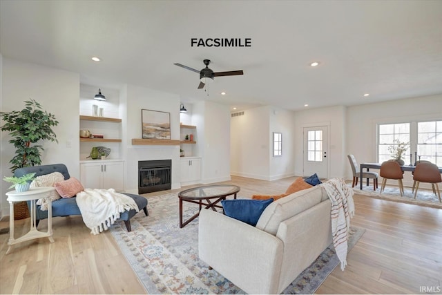910 S Lantern Ln, Ellettsville, IN 47429 - living room featuring a glass covered fireplace, light wood-type flooring, recessed lighting, ceiling fan, and built in features