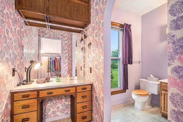 222 Queen St, Goshen, IN 46528 - bathroom featuring vanity, toilet, baseboards, and wallpapered walls