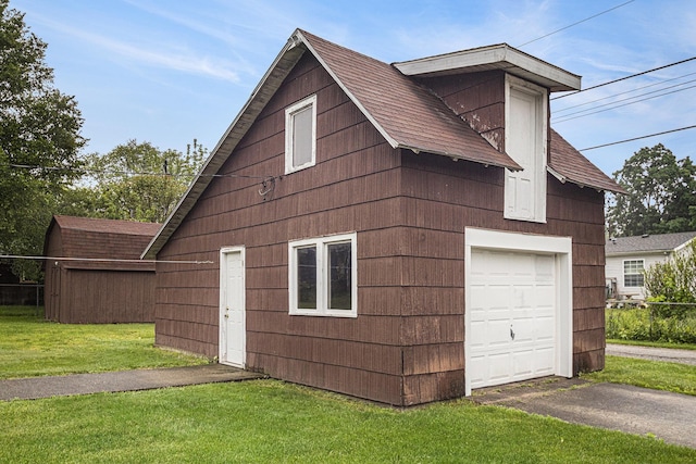 222 Queen St, Goshen, IN 46528 - view of home's exterior featuring a yard, a shingled roof, asphalt driveway, an outdoor structure, and a garage