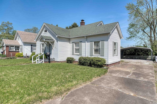 517 W Locust St, Boonville, IN 47601 - view of front of property with a chimney, a carport, concrete driveway, roof with shingles, and a front yard