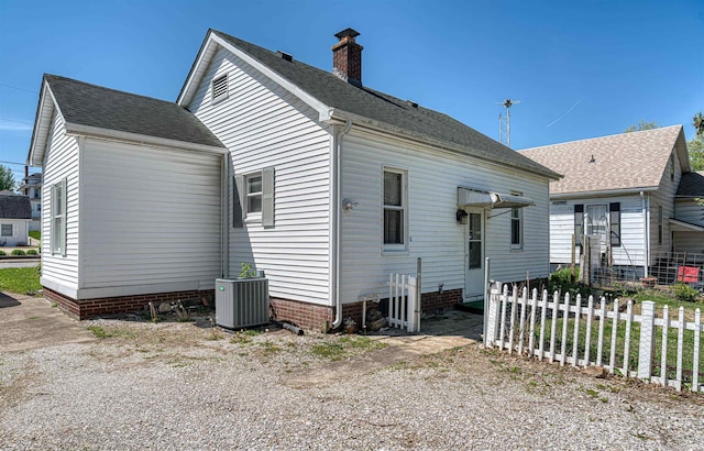 517 W Locust St, Boonville, IN 47601 - rear view of property featuring cooling unit, a shingled roof, and a chimney