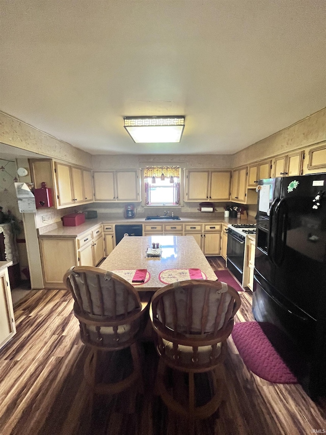 12537 E 340 S, Greentown, IN 46936 - kitchen with black fridge, range with gas cooktop, light countertops, dark wood finished floors, and a sink