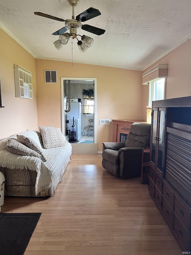 12537 E 340 S, Greentown, IN 46936 - living area with a textured ceiling, wood finished floors, a ceiling fan, crown molding, and a glass covered fireplace