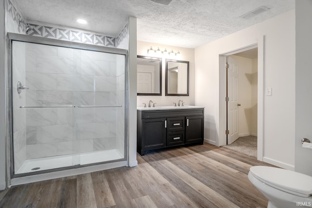 355 Blinn Ave, Frankfort, IN 46041 - full bath with wood finished floors, double vanity, a stall shower, baseboards, and a textured ceiling