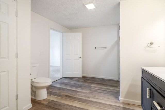 355 Blinn Ave, Frankfort, IN 46041 - bathroom with vanity, toilet, wood finished floors, a textured ceiling, and baseboards