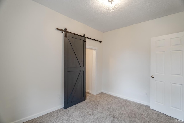 355 Blinn Ave, Frankfort, IN 46041 - unfurnished bedroom with a barn door, light colored carpet, a textured ceiling, and baseboards