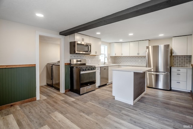 355 Blinn Ave, Frankfort, IN 46041 - kitchen featuring stainless steel appliances, separate washer and dryer, white cabinetry, tasteful backsplash, and light countertops
