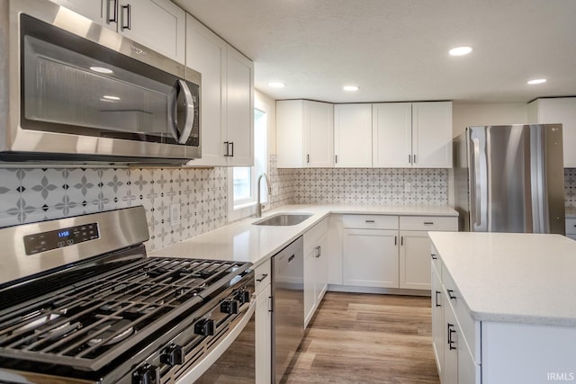 355 Blinn Ave, Frankfort, IN 46041 - kitchen featuring appliances with stainless steel finishes, a sink, light wood-style flooring, white cabinets, and recessed lighting