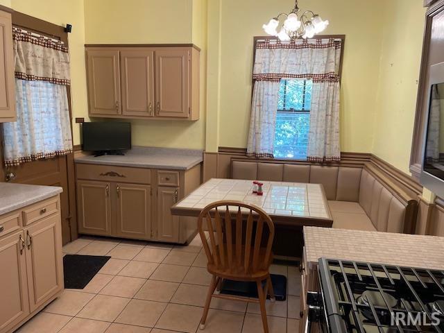 2725 Marion Ave, Evansville, IN 47712 - dining room with a chandelier, a wainscoted wall, and light tile patterned floors