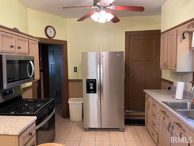 2725 Marion Ave, Evansville, IN 47712 - kitchen featuring stainless steel appliances, ceiling fan, light countertops, a sink, and light tile patterned flooring