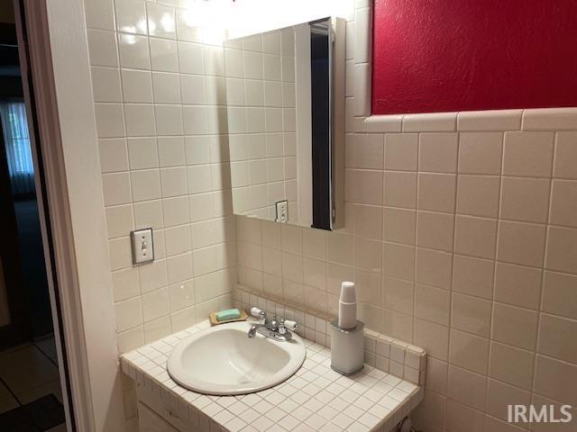 2725 Marion Ave, Evansville, IN 47712 - bathroom with tile walls, vanity, and tasteful backsplash