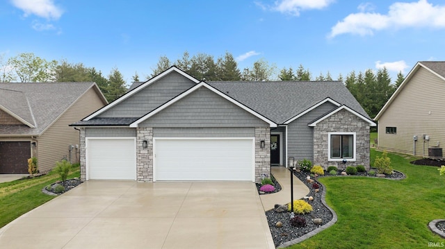15332 Annabelle Pl, Leo, IN 46765 - craftsman-style house featuring stone siding, an attached garage, concrete driveway, a front yard, and central AC unit