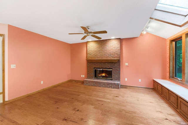 2711 Spring Creek Dr, Fort Wayne, IN 46808 - unfurnished living room with light wood-type flooring, a brick fireplace, ceiling fan, and baseboards