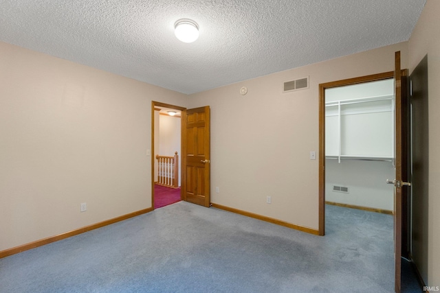 2711 Spring Creek Dr, Fort Wayne, IN 46808 - unfurnished bedroom featuring a textured ceiling, a walk in closet, carpet flooring, baseboards, and a closet