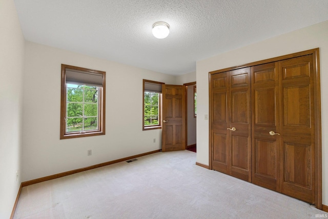 2711 Spring Creek Dr, Fort Wayne, IN 46808 - unfurnished bedroom with baseboards, light colored carpet, a textured ceiling, and a closet