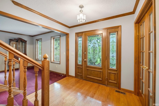 2711 Spring Creek Dr, Fort Wayne, IN 46808 - foyer featuring light wood finished floors, baseboards, a textured ceiling, stairs, and a chandelier