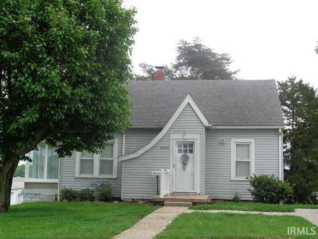 2626 Brosmer St, Jasper, IN 47546 - view of front of property featuring a chimney, a front yard, and a shingled roof