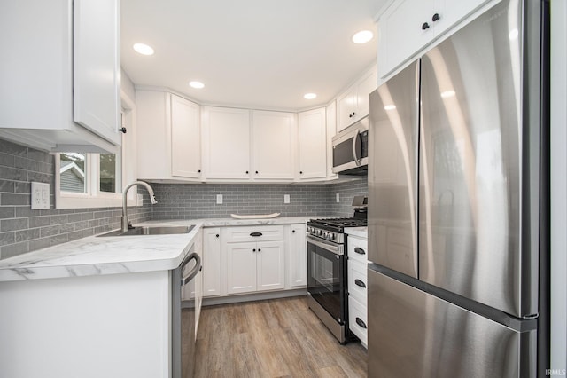 4113 York Rd, South Bend, IN 46614 - kitchen featuring appliances with stainless steel finishes, a sink, white cabinetry, backsplash, and recessed lighting