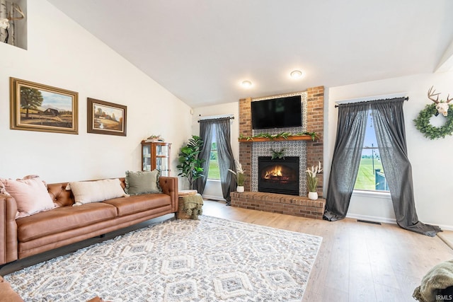 65600 Ash Rd, Wakarusa, IN 46573 - living area with wood finished floors, a fireplace, lofted ceiling, and baseboards
