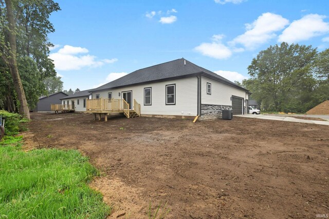 51650 Prescott Ave, South Bend, IN 46637 - rear view of property featuring a wooden deck, an attached garage, central AC unit, and driveway