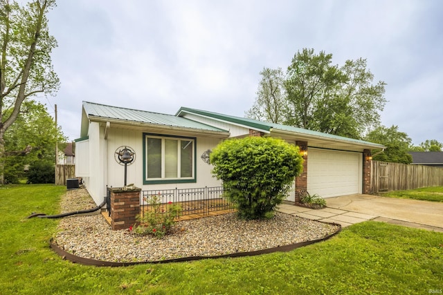 409 N Dorothy St, Monon, IN 47959 - view of front of property with central AC, driveway, an attached garage, and metal roof