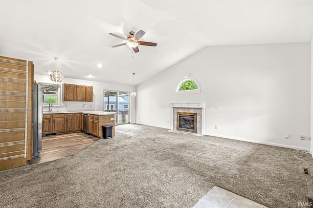 4019 Riverside Dr, South Bend, IN 46628 - unfurnished living room featuring a sink, carpet floors, ceiling fan, a fireplace, and vaulted ceiling