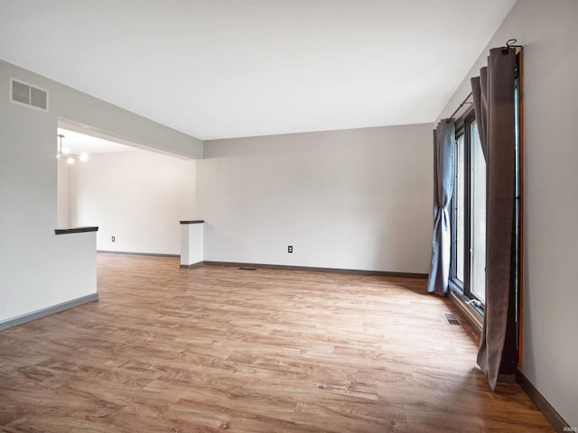 9826 Flag Stone Pl, Fort Wayne, IN 46804 - empty room with wood finished floors, baseboards, and a chandelier