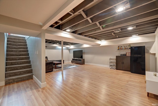 3231 N Kingsley Dr, Bloomington, IN 47404 - finished below grade area with stairs, a dry bar, baseboards, and light wood-type flooring