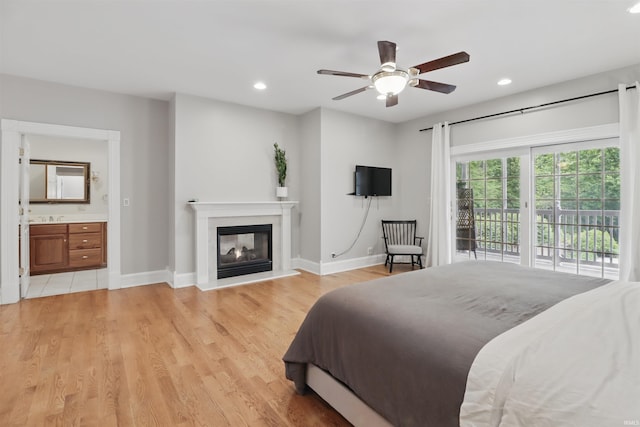 bedroom with access to outside, recessed lighting, a multi sided fireplace, light wood finished floors, and baseboards